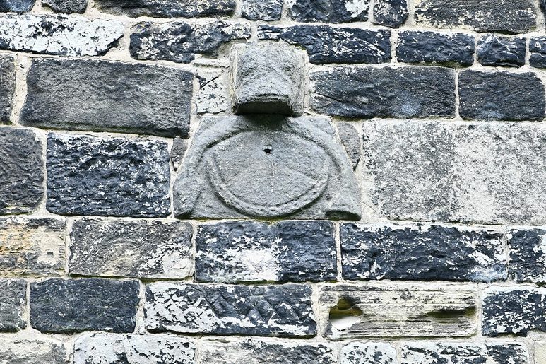 An ancient carved stone sundial set high in the south wall of Escomb church