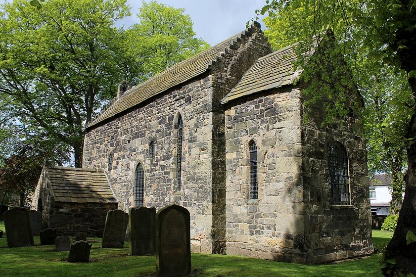 Escomb Saxon Church, County Durham, a small, tall and narrow stone church in a round churchyard surrounded by houses