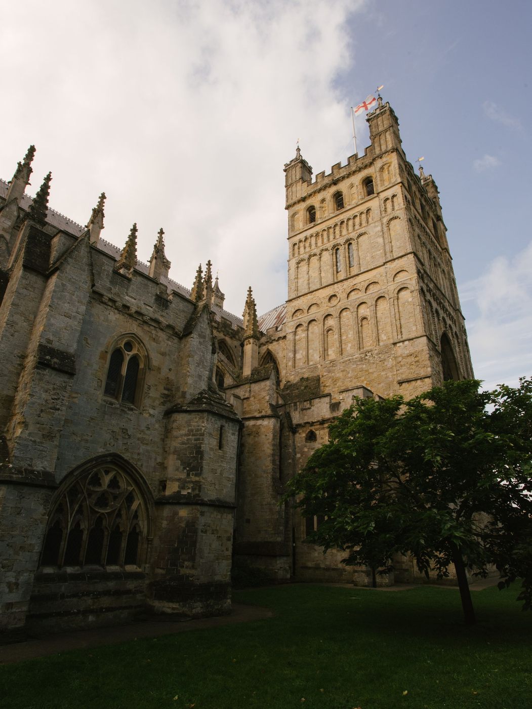 One of the twin Norman towers of Exeter Cathedral rising above the long roof of the nave