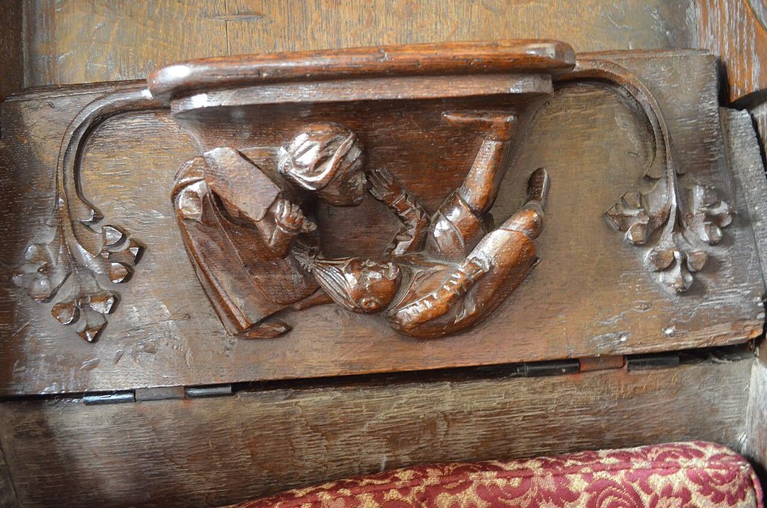 A carved wooden misericord under a choir stall at St Mary's, Fairford