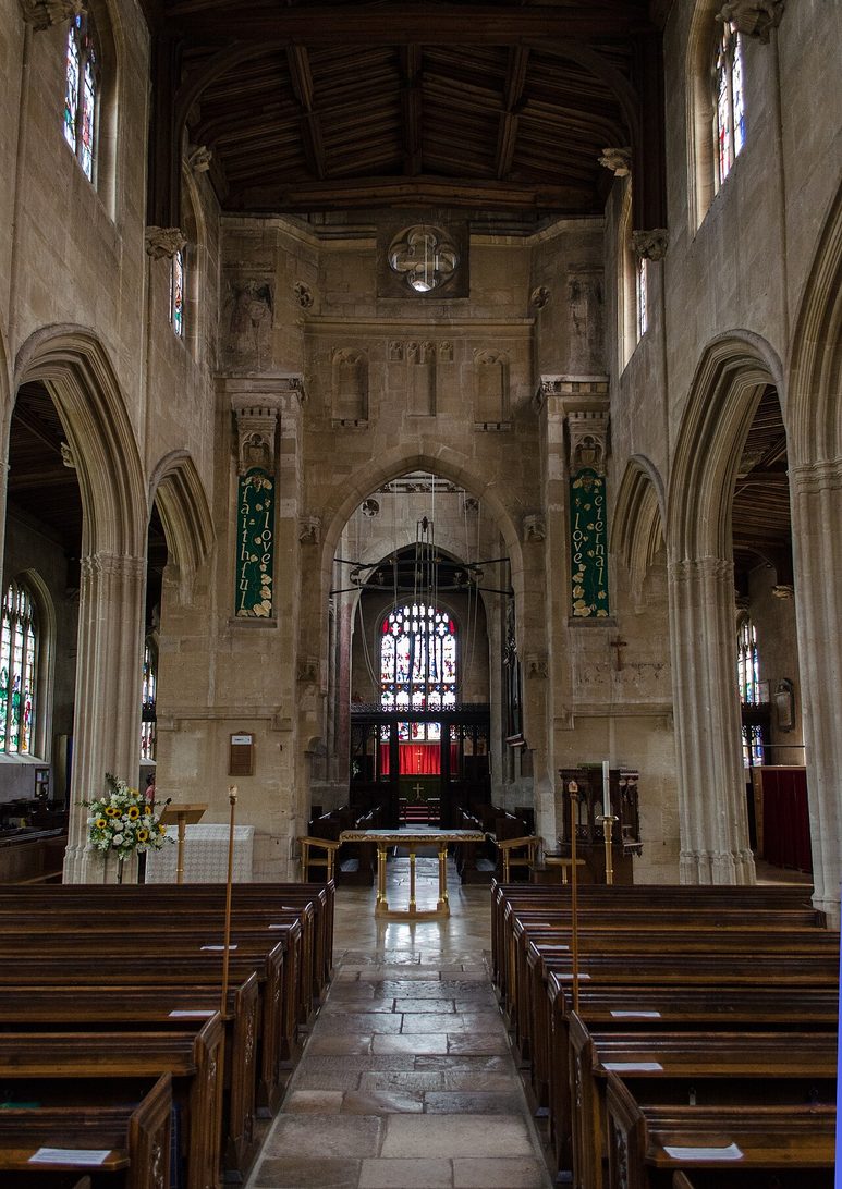 The nave of St Mary's, Fairford, looking east through the tower arch to the chancel screen and east window