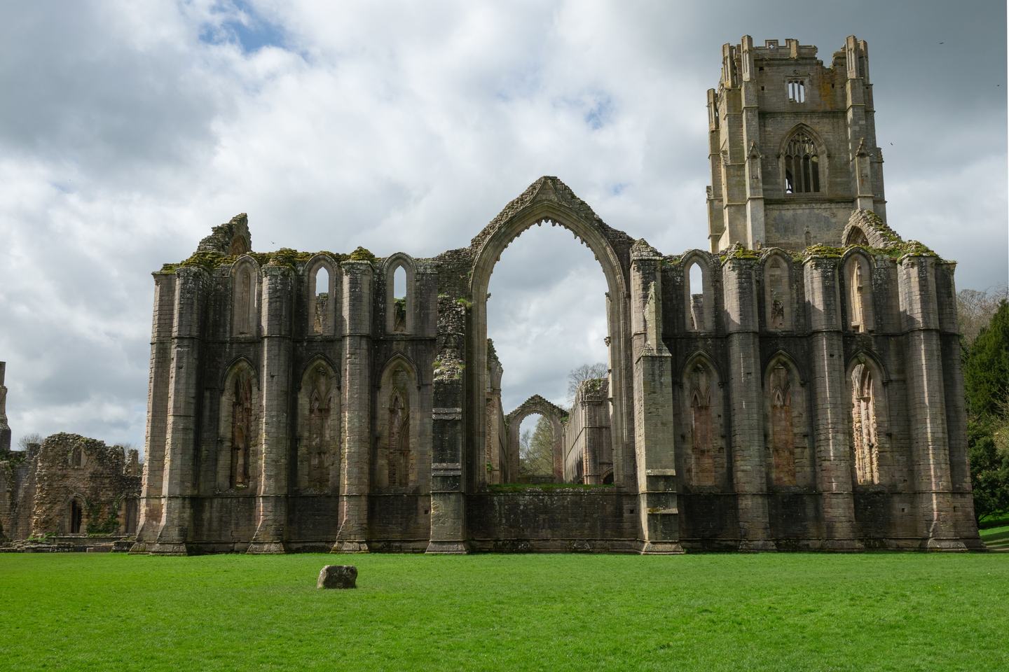 The ruined church of Fountains Abbey with its great tower, standing on the lawns of the Skell valley