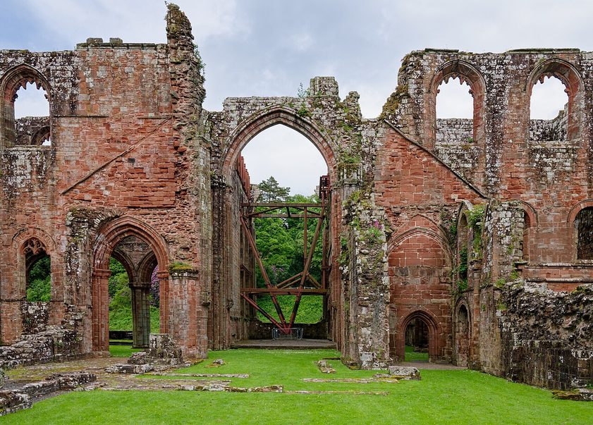 The ruined church of Furness Abbey seen from the west, looking along the nave to the tall arches of the crossing