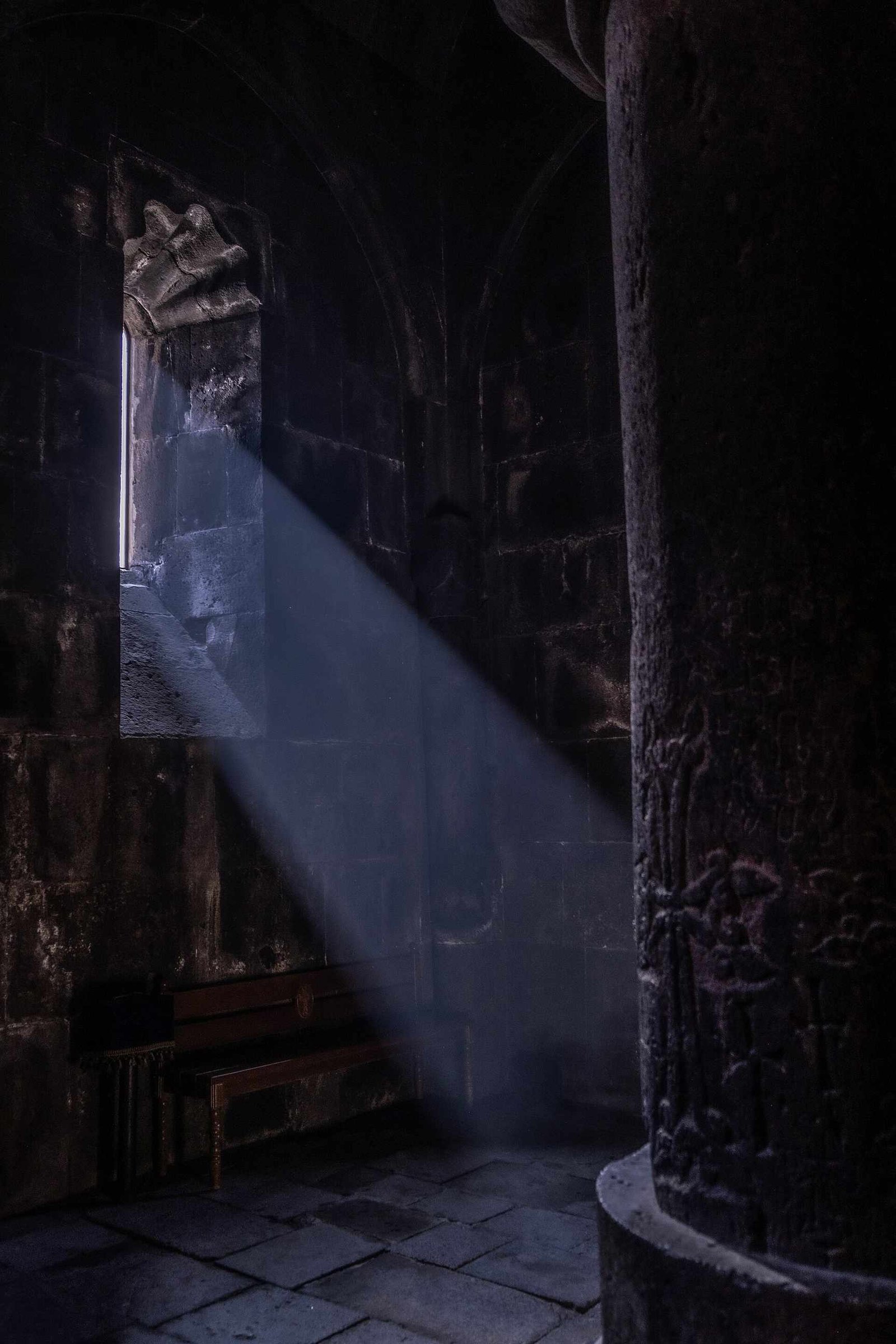 A shaft of light falling into a rock-cut chamber at Geghard Monastery