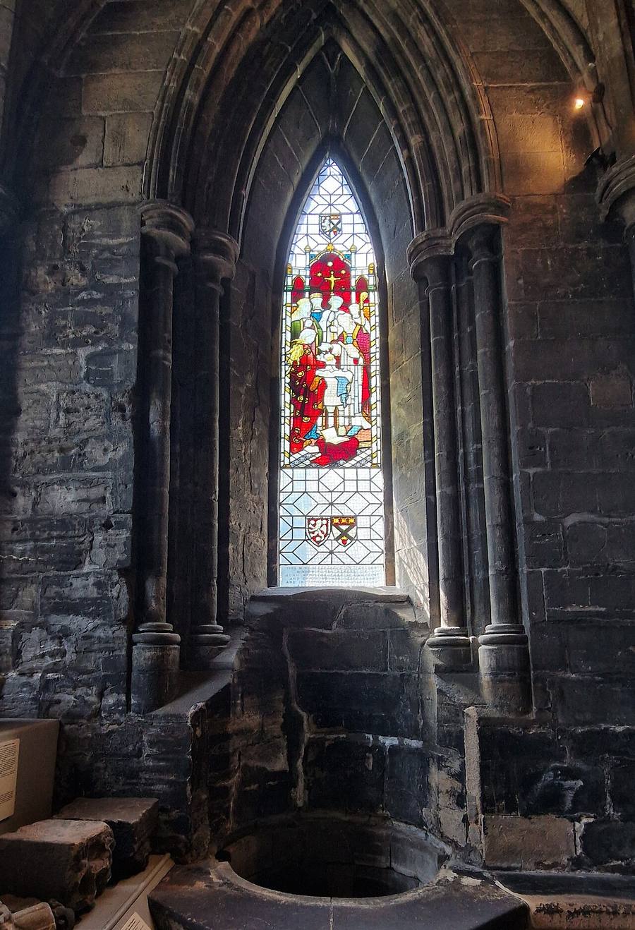 St Mungo's Well in the Lower Church of Glasgow Cathedral, with a stained glass window