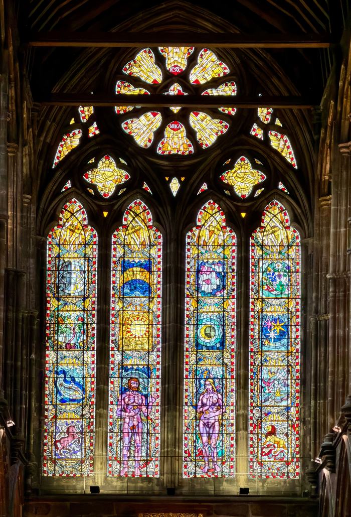 A large stained glass window with four lights and a rose in Glasgow Cathedral