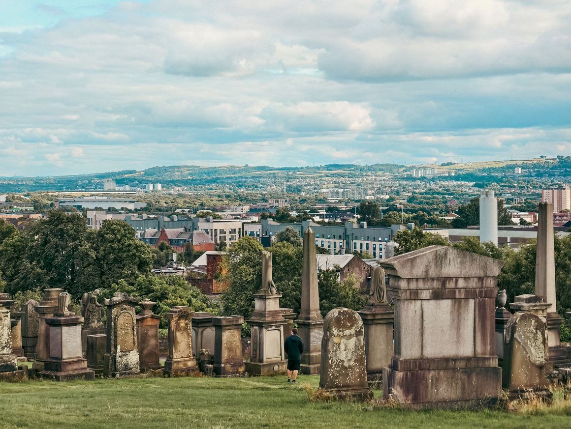 Victorian monuments in the Glasgow Necropolis with the city beyond