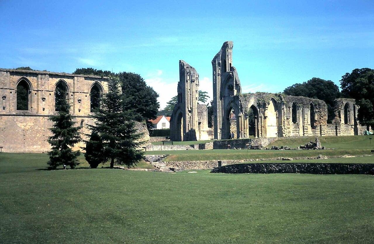 The ruins of Glastonbury Abbey spread across mown grass