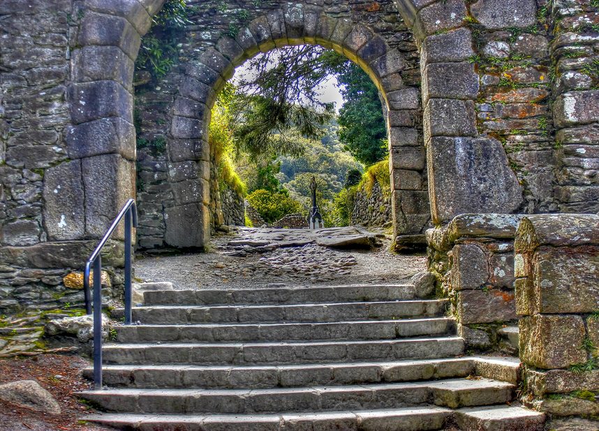 The double stone arches of the monastic gateway at Glendalough with steps leading through