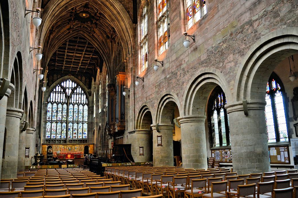 Massive round Norman piers in the nave of Great Malvern Priory with Perpendicular windows above
