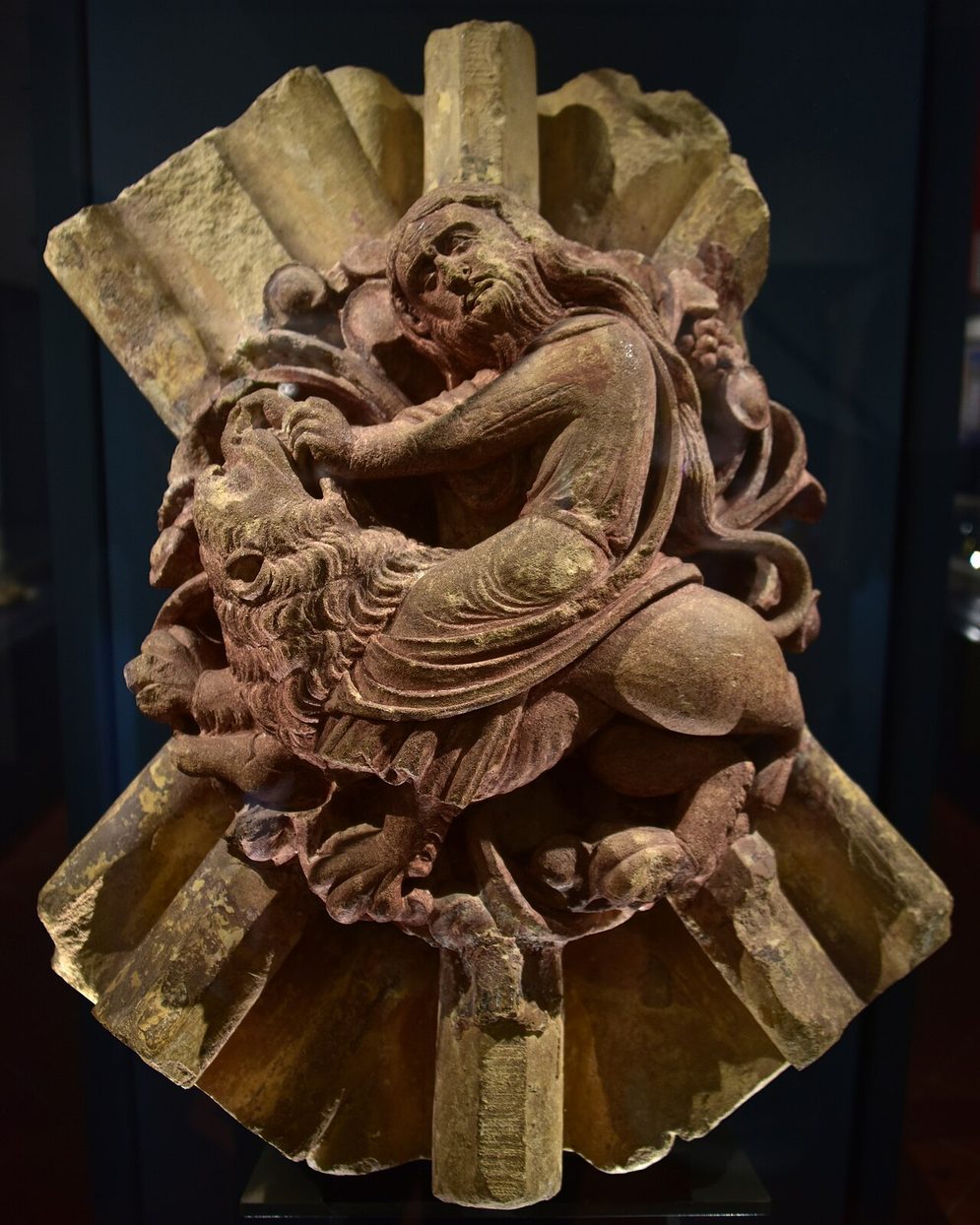 A carved stone roof boss from Hailes Abbey showing Samson wrestling a lion, displayed in the site museum
