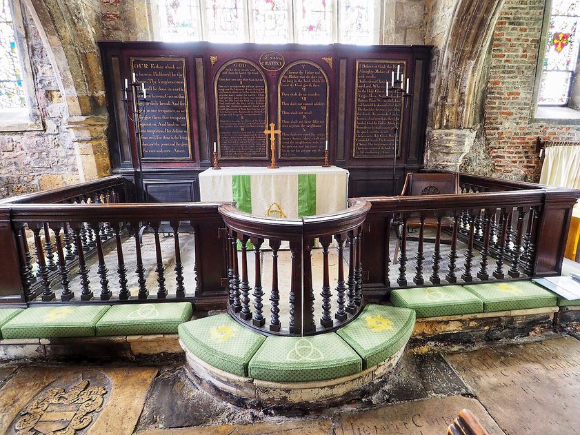 Wooden communion rails with green kneelers in front of the altar at Holy Trinity, Goodramgate