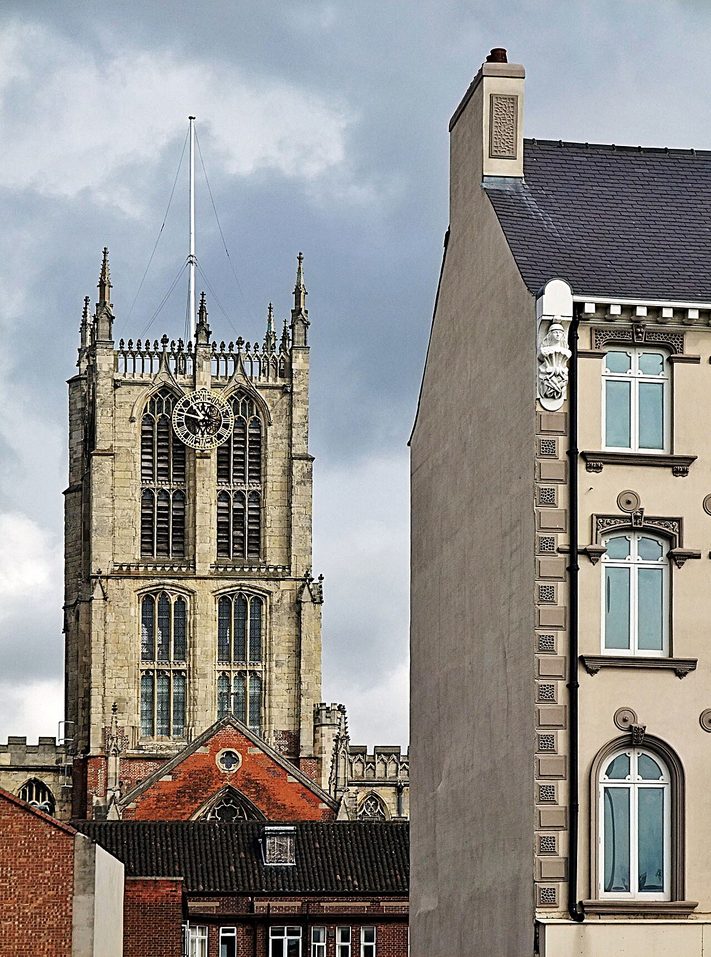 The tall Perpendicular central tower of Hull Minster seen from a street in the Old Town