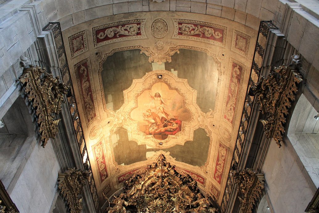 The painted ceiling of the Igreja do Carmo, pale and gilded, framed by carved gilt-wood ornament