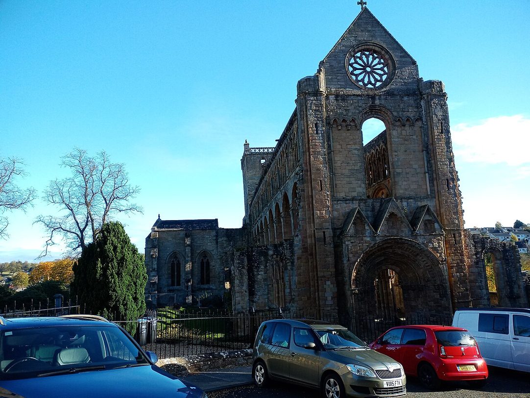 The west front of Jedburgh Abbey with its round-arched doorway and rose window, seen from the street