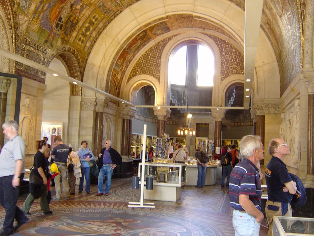 Visitors in the Memorial Hall inside the base of the old tower, with mosaics, a marble floor and display cases