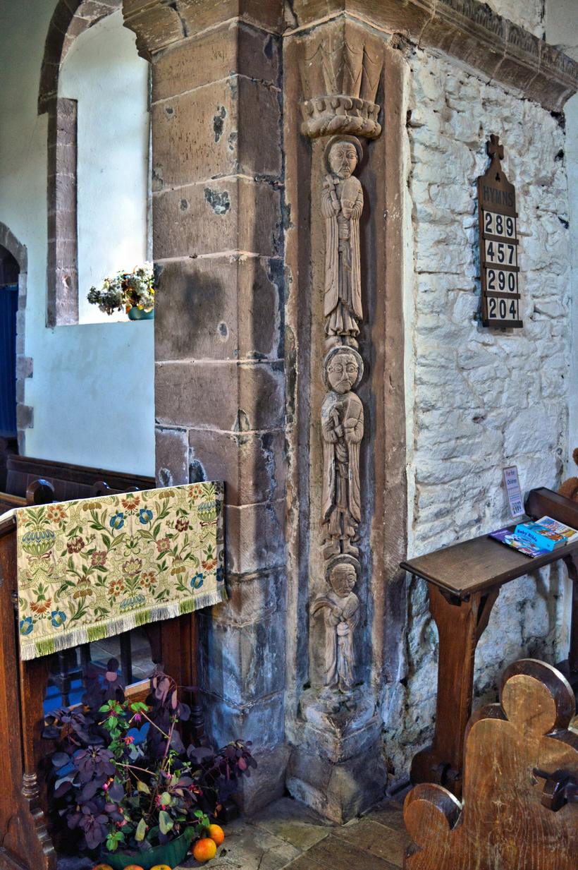 The Norman chancel arch inside Kilpeck church with carved figures stacked on its shafts