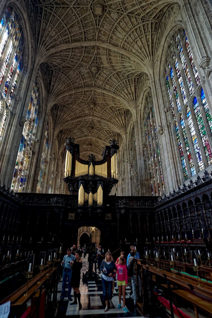 The dark carved oak screen of King's College Chapel with the organ above it