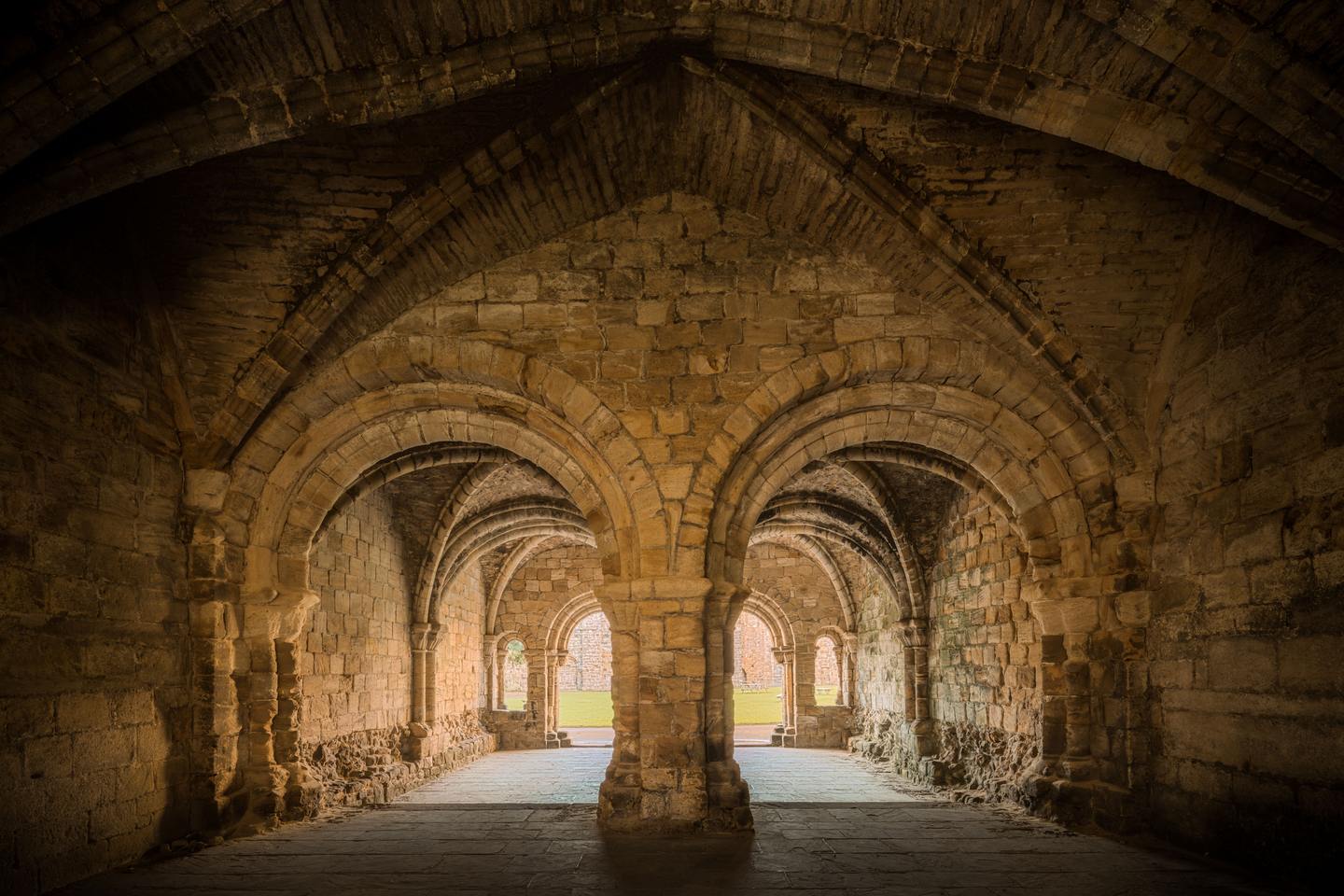 The rib-vaulted chapter house of Kirkstall Abbey with its central pillars and arches
