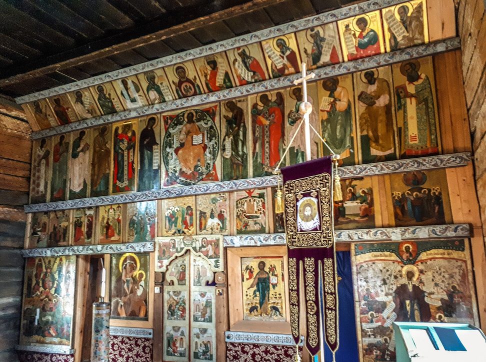 Rows of old painted icons set on wooden beams inside one of the Kizhi churches