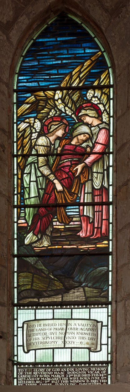 A tall, narrow Victorian stained glass window with figures in Lanercost Priory church