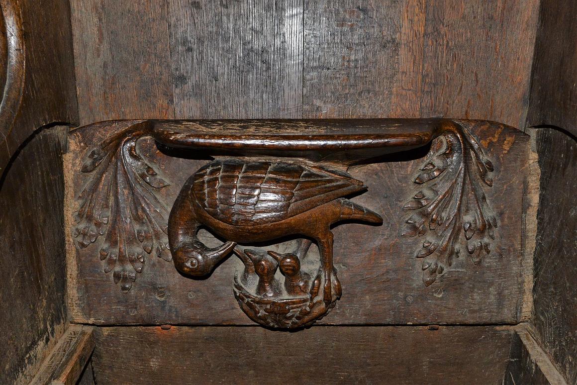A carved medieval misericord at Lavenham church showing a pelican feeding her young