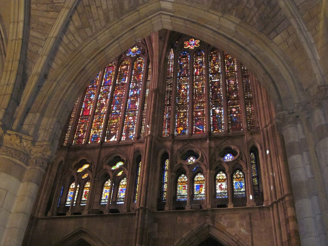 Looking up at the clerestory and triforium windows of León Cathedral, filled with coloured glass