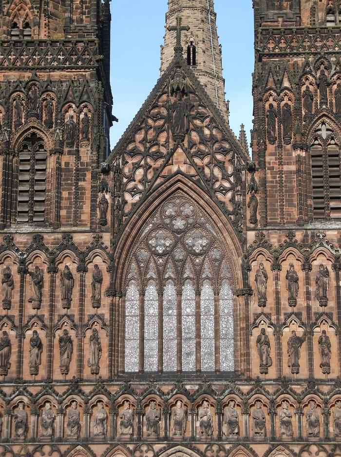 Rows of carved figures on the west front of Lichfield Cathedral below the twin western spires