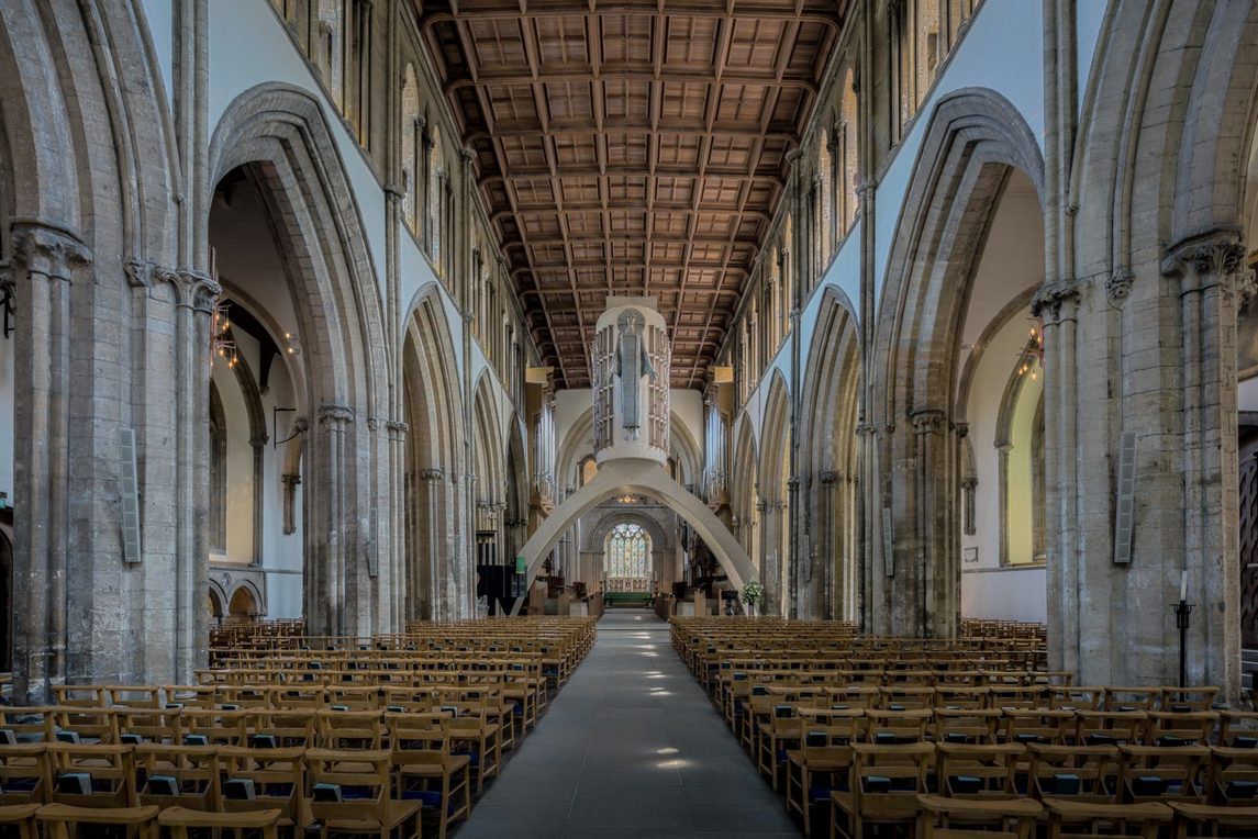 The nave of Llandaff Cathedral looking east to a concrete arch carrying Epstein's aluminium figure of Christ in Majesty