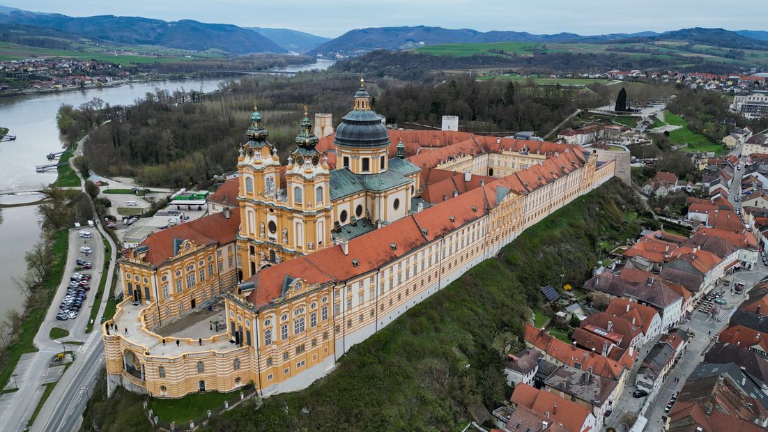 Aerial view of Melk Abbey, its long buildings stretching along the ridge above the town and the Danube