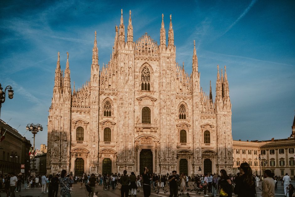 The marble facade and spires of Milan Cathedral in evening light