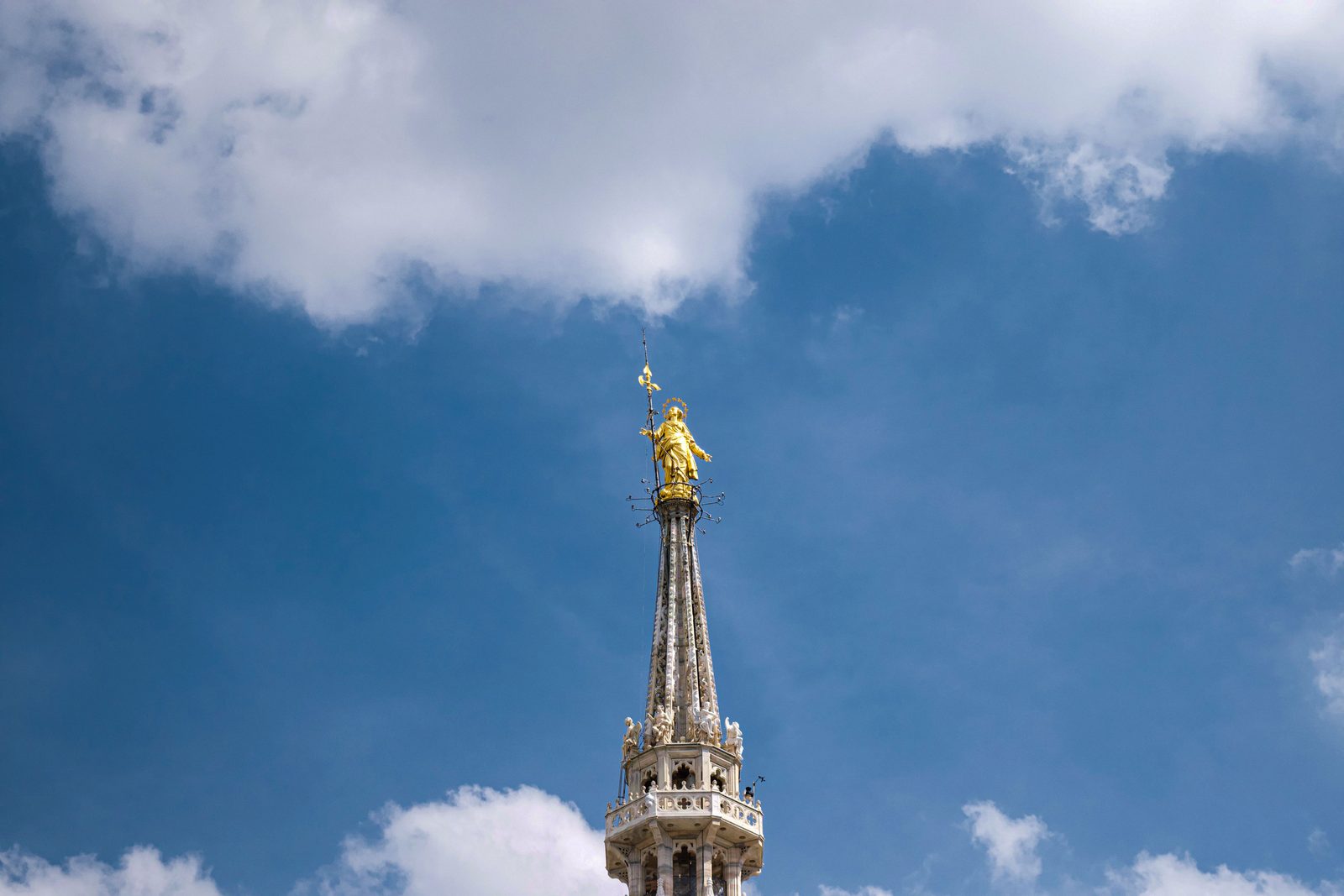 The gilded statue of the Madonnina on top of the main spire of Milan Cathedral