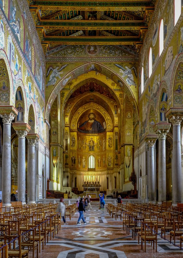 The long nave of Monreale Cathedral, its walls covered with gold mosaics, under a painted timber ceiling
