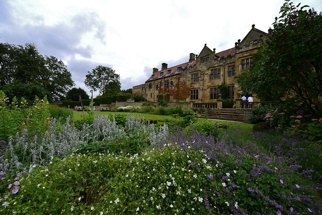 The stone manor house at Mount Grace Priory seen across its Arts and Crafts garden