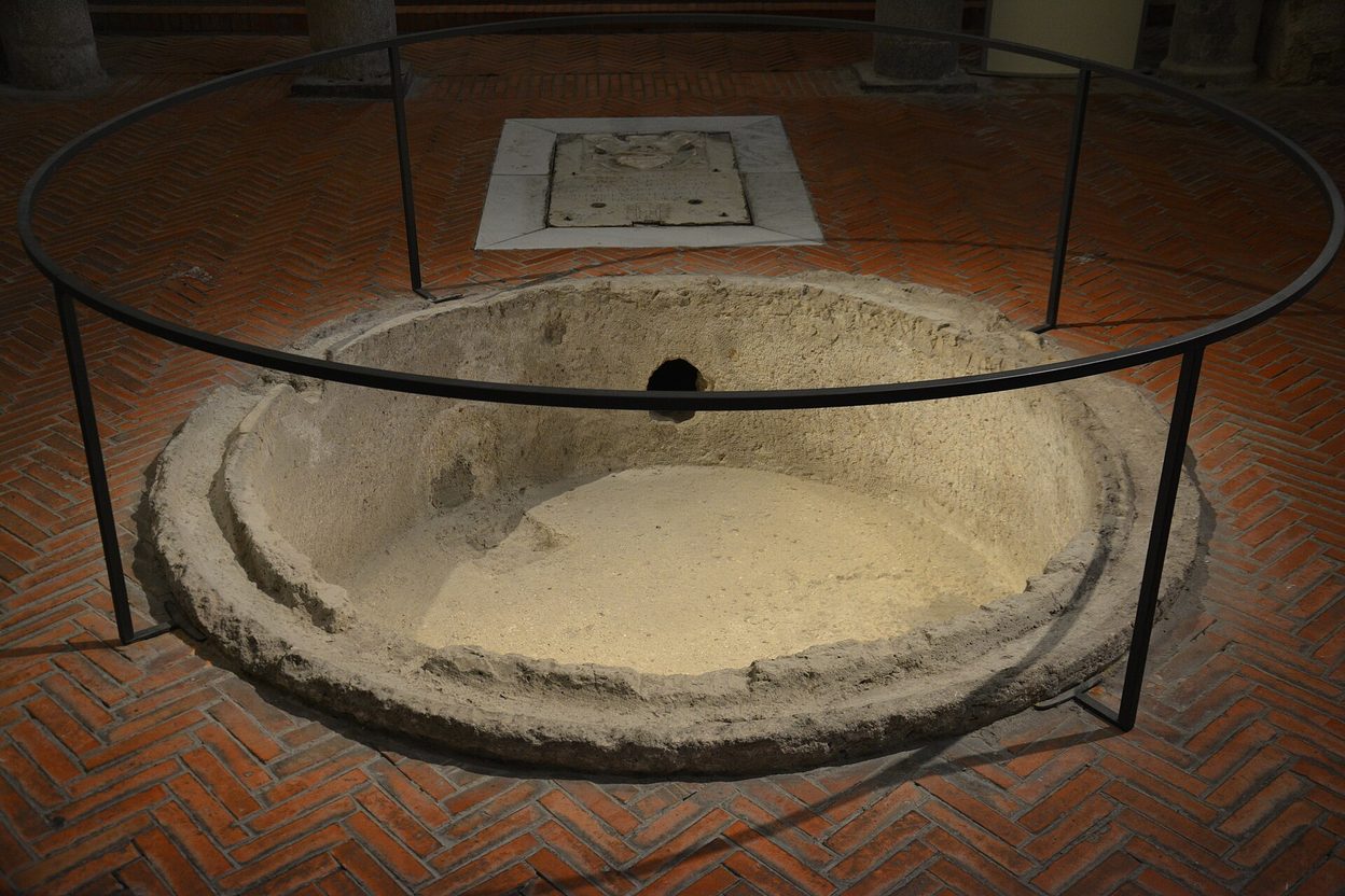 The sunken early Christian font in the floor of the baptistery of San Giovanni in Fonte, Naples, inside a protective rail