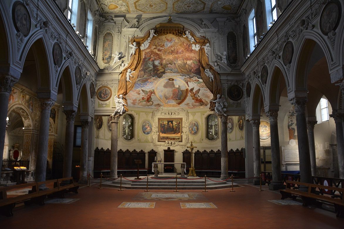 The nave of the Basilica of Santa Restituta inside Naples Cathedral, with ancient columns and a painted Baroque ceiling