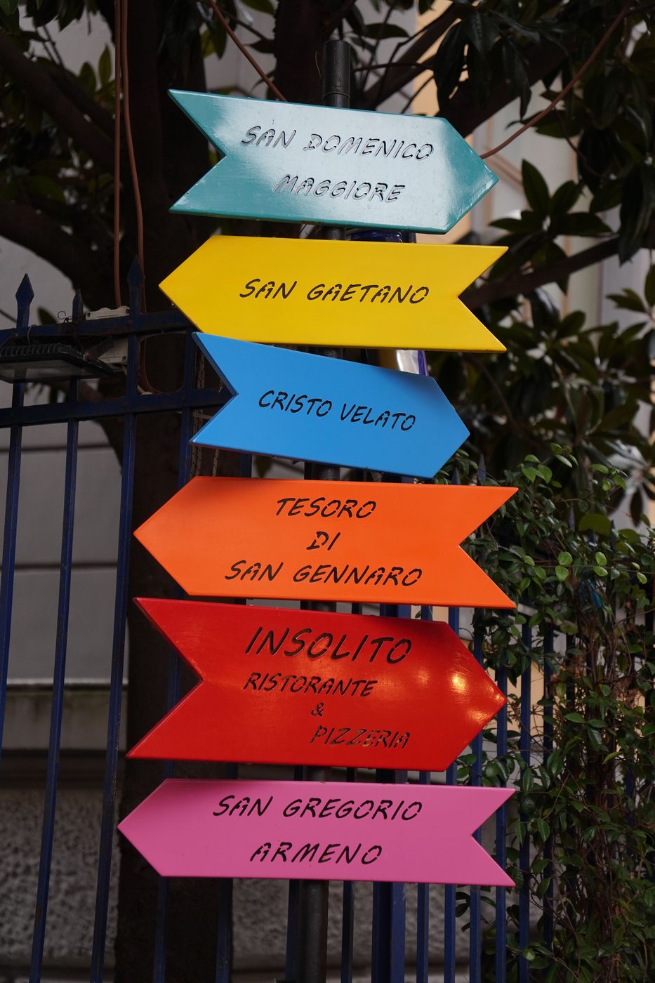 Colourful arrow signs in Naples pointing to San Domenico Maggiore, San Gaetano, the Cristo Velato, the Treasure of San Gennaro and San Gregorio Armeno