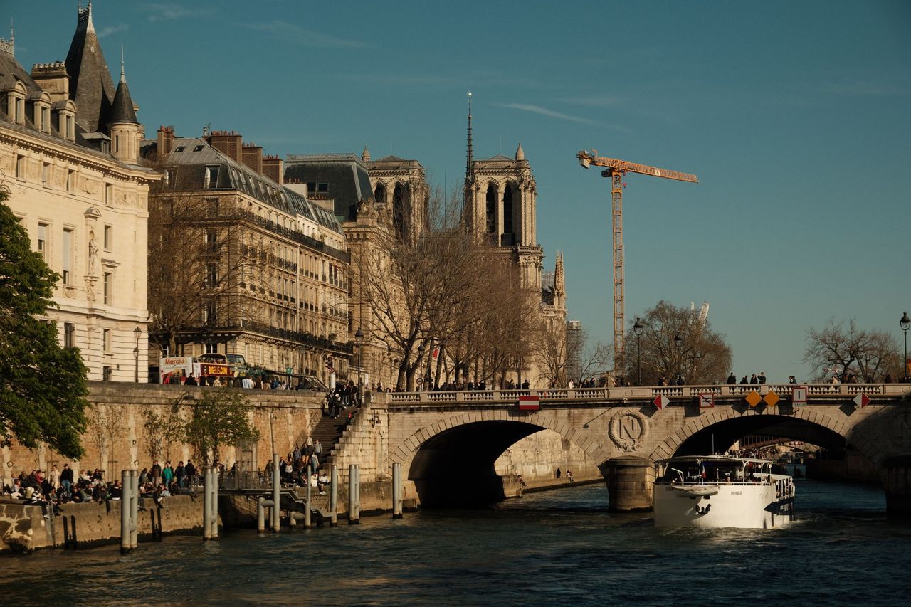 Notre-Dame de Paris seen across the Seine beyond a stone bridge