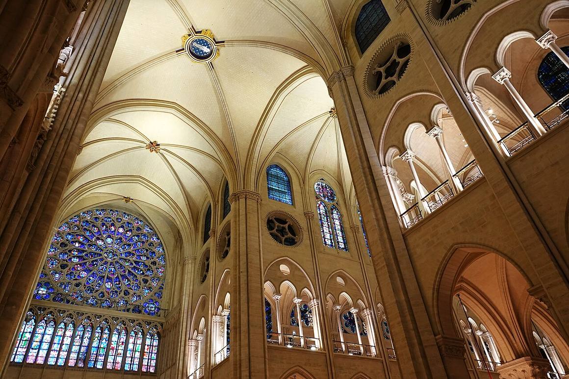 A transept rose window above the cleaned stone walls inside Notre-Dame de Paris