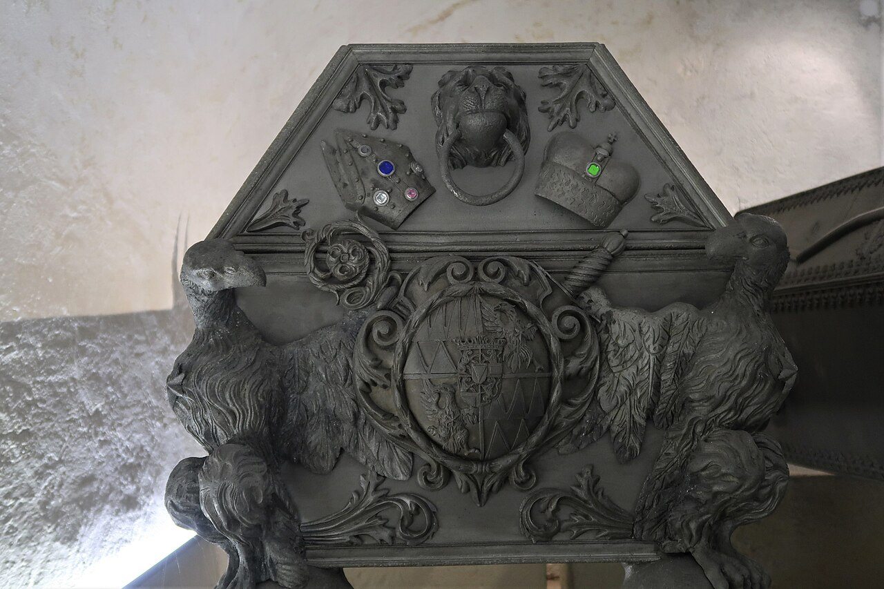 An ornate pewter coffin with a coat of arms in the crypt beneath Olomouc cathedral
