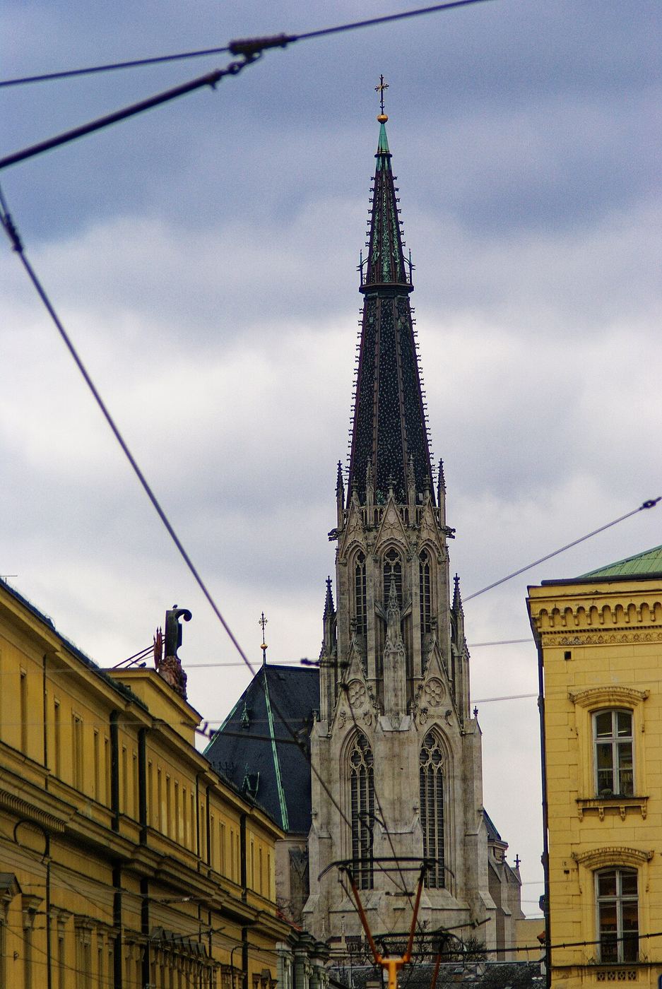 The south tower of St Wenceslas Cathedral seen from a street with tram wires