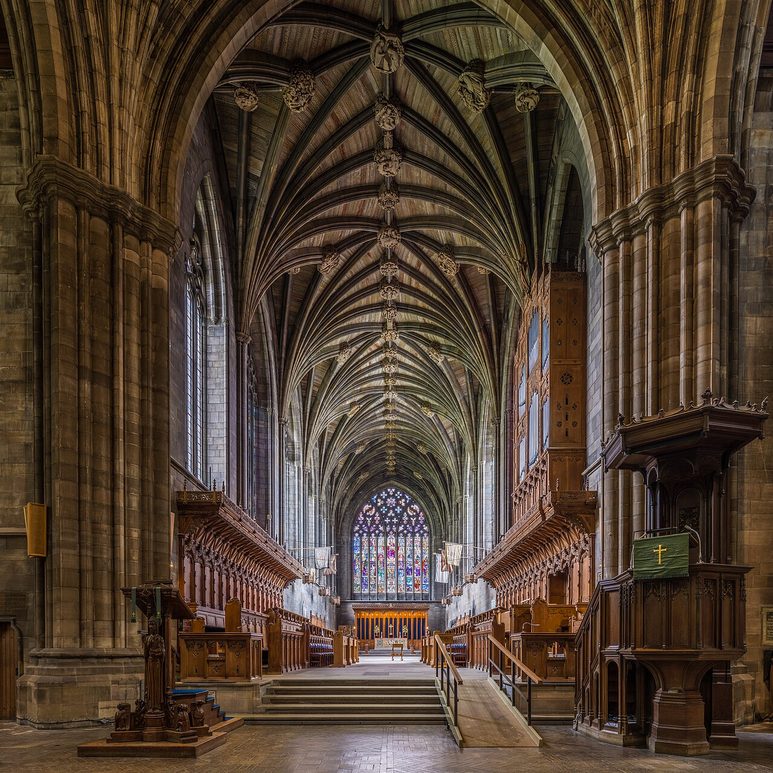 The choir of Paisley Abbey seen from the crossing, with its ribbed stone vault, carved choir stalls and the great east window
