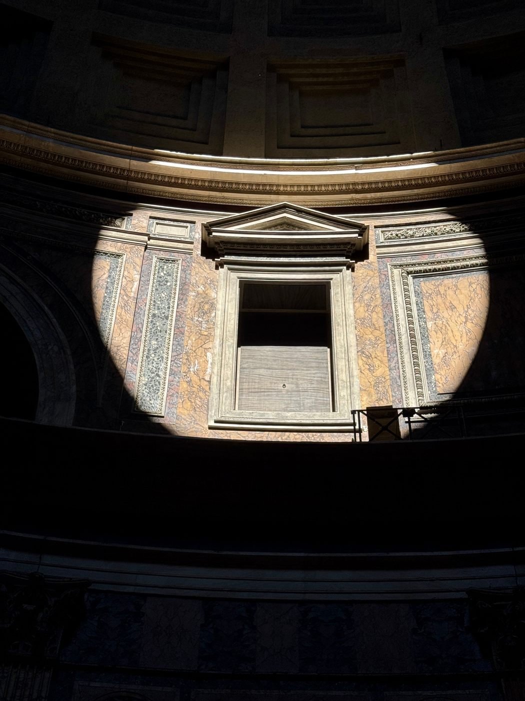 A disc of sunlight from the oculus falling across the Pantheon's interior wall