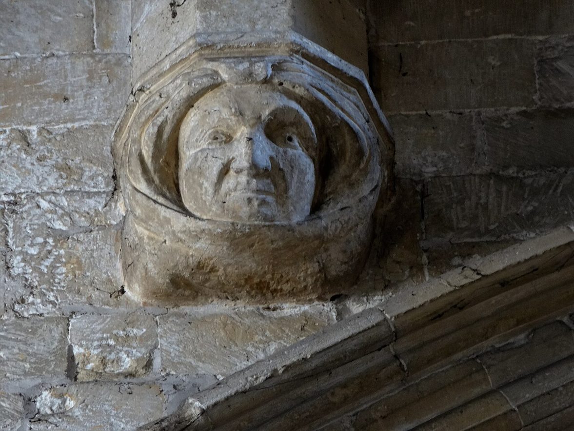 A carved stone head in a hood on a corbel inside St Patrick's Church, Patrington