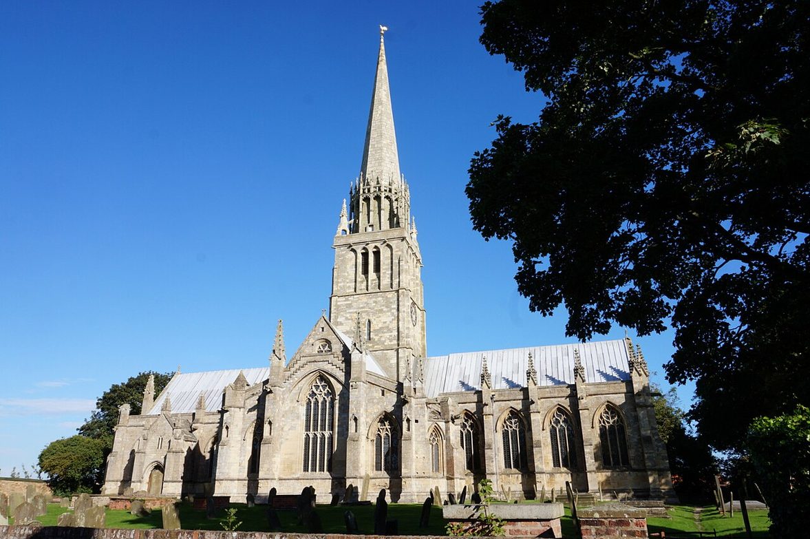St Patrick's Church, Patrington, in the East Riding of Yorkshire, with its slender central spire rising above the churchyard trees