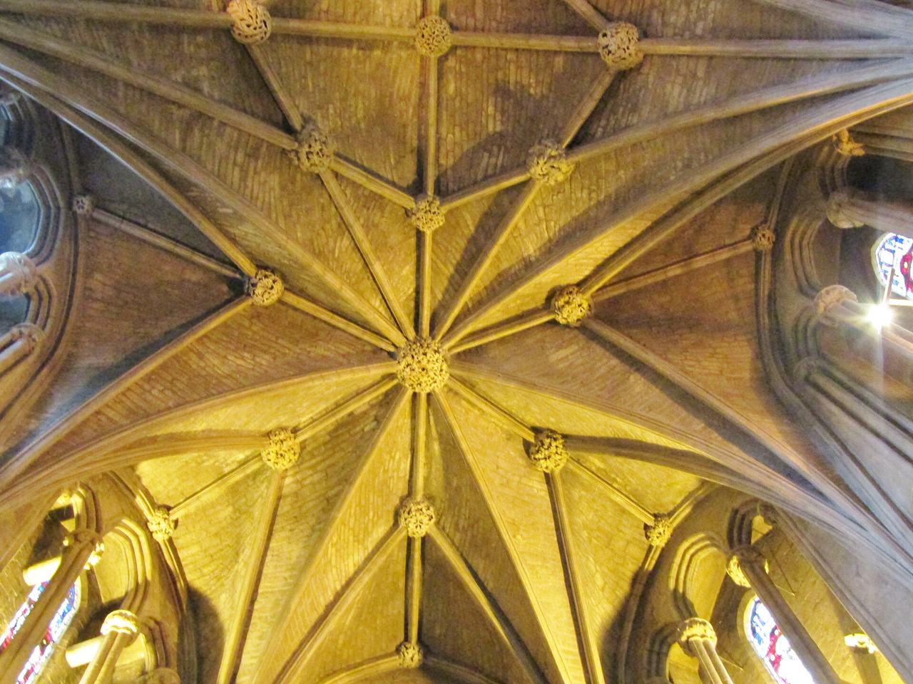 The ribbed stone vault of Pershore Abbey with its many ribs meeting in carved bosses