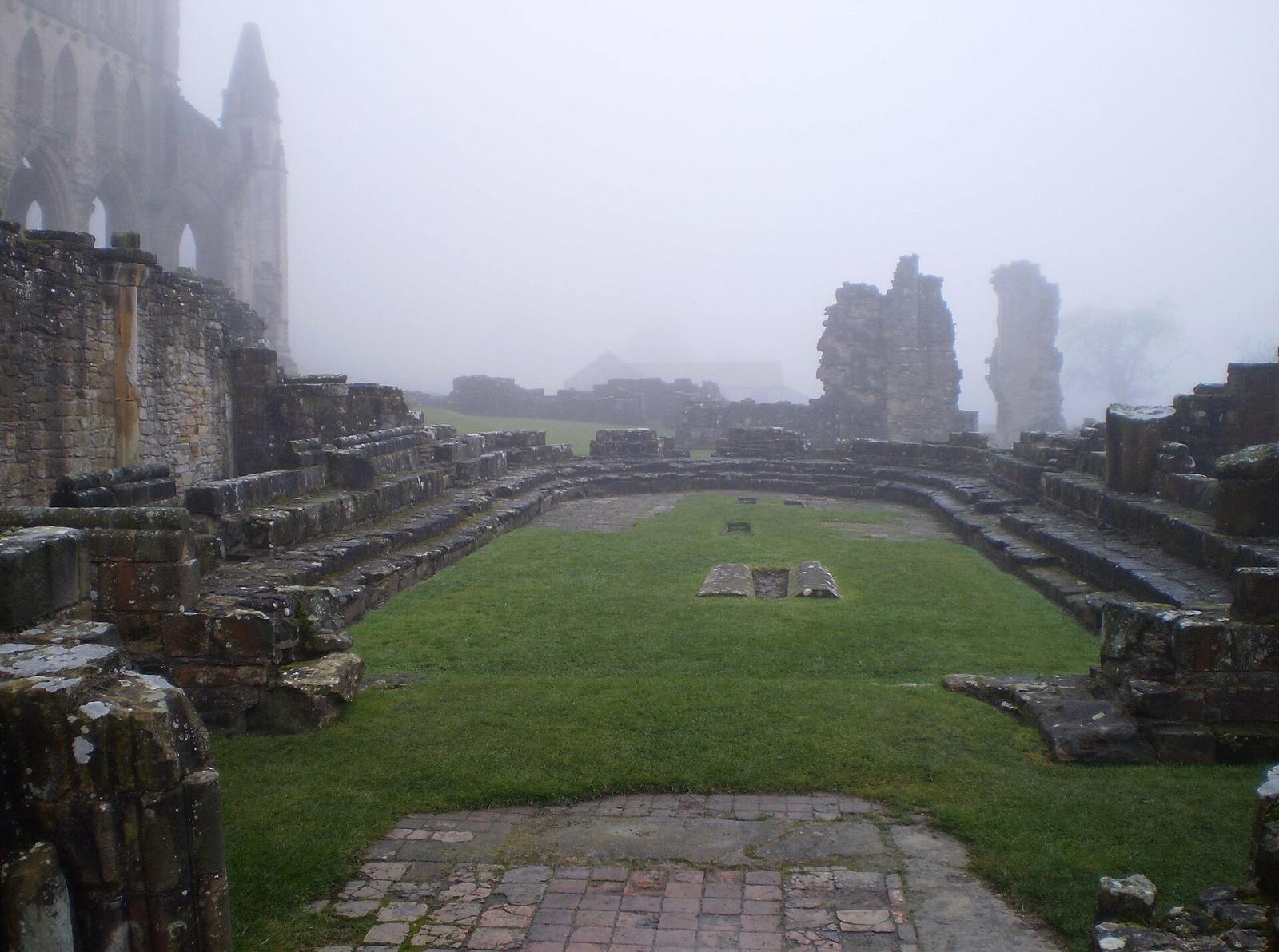 The remains of the chapter house at Rievaulx Abbey with its column bases on the grass