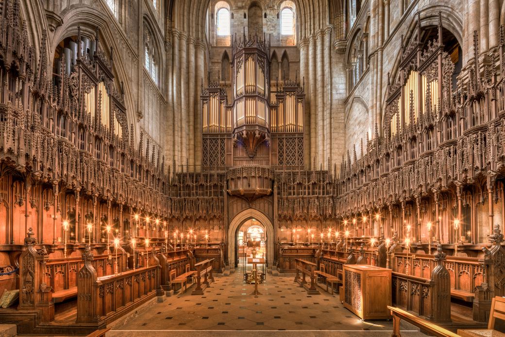 The quire of Ripon Cathedral with its tall carved wooden canopies and the east window