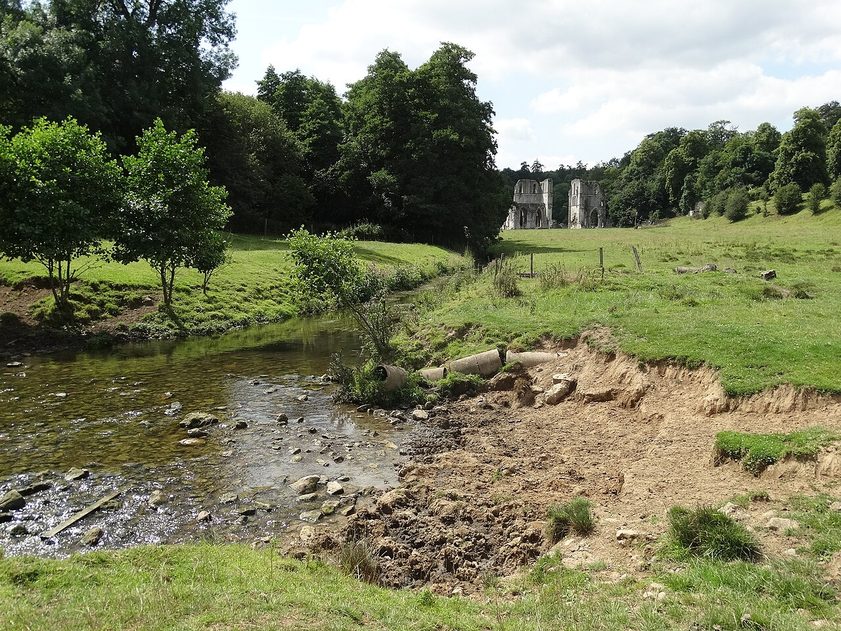 The valley of Maltby Beck with the ruins of Roche Abbey in the distance among trees