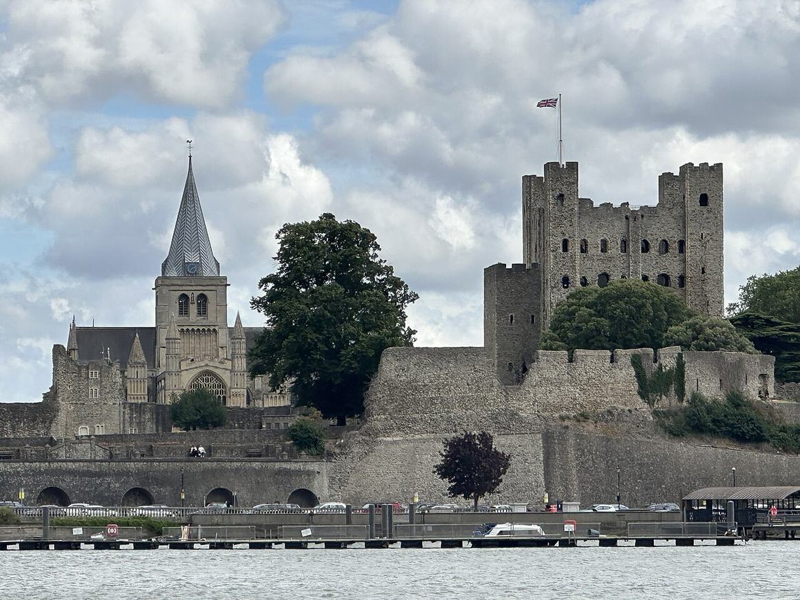 Rochester Cathedral's spire beside the keep of Rochester Castle seen across the River Medway